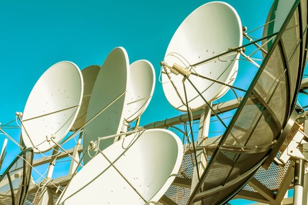 Satellite dish on blue sky backgroundの写真素材