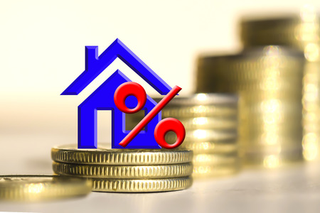 Real estate symbol in the background of bars coins. The concept of financial instability in the market.の写真素材