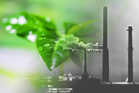 Industrial factory chimneys on background of green plants. The concept of relevance for the protection of natureの写真素材