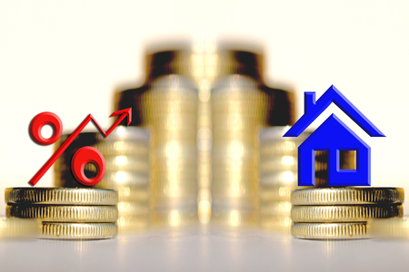 The percent symbol and real estate and on the background of bars coins. The concept of mortgage lendingの写真素材