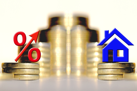 The percent symbol and real estate and on the background of bars coins. The concept of mortgage lendingの写真素材