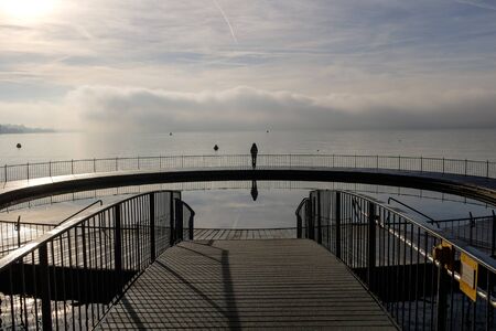 Woman contemplating the horizon standing on a pier in Zurich, Switzerland
