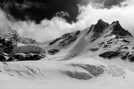 Man descending the Gran Paradiso glacier during winter on the north west side. The peack is the...