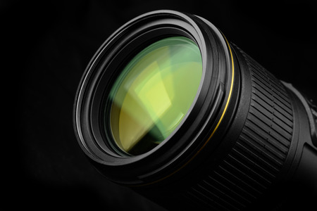 Reflection on a colored lens of a camera lens on black background