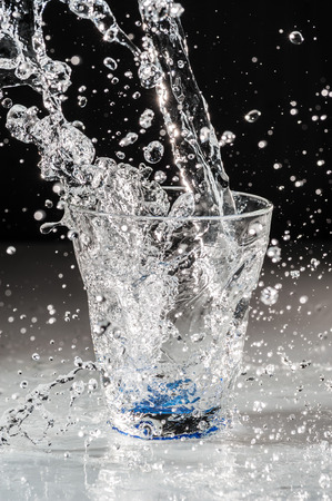 Water falling into a glassの写真素材
