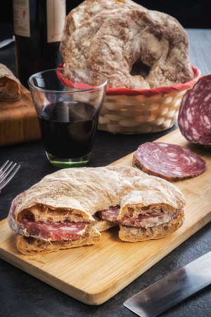 donut Bread stuffed with Italian salami homegrown and a glass of red wineの写真素材