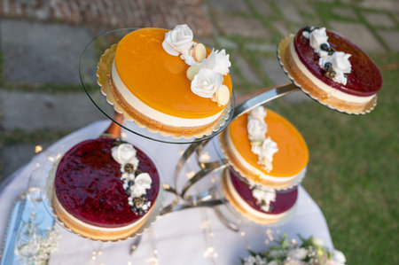Delicious wedding cake with blueberry, orange and white flowers on topの写真素材