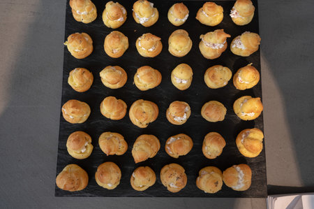 Cream puff on black background, top view. Eclairs