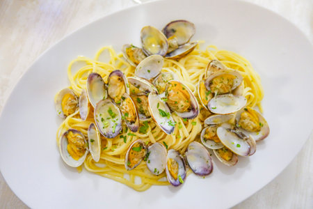 Spaghetti with clams on a white plate. Italian cuisine.