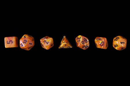 RPG set orange dice for playing role playing games on black blackground.