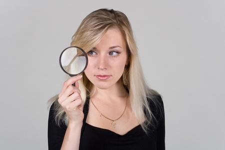 young girl looking through a magnifying glassの写真素材