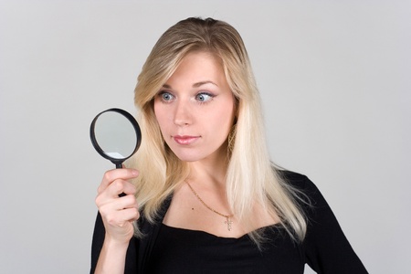 young girl looking through a magnifying glassの写真素材