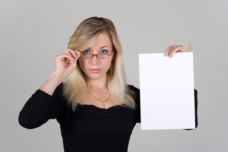 Young girl shows a blank sheet of paperの写真素材
