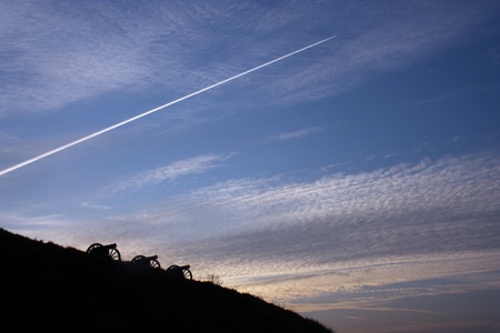 silhouettes of three big guns in the evening skyの写真素材