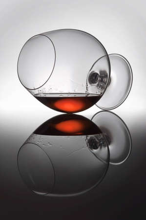 Detailed shooting of a glass with alcohol on a gleam, liquid drops flow down on glass wallsþThe...
