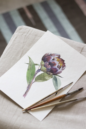 Workspace. Exotic flower painted with watercolor, paintbrush, isolated on white background. Overhead view. Flat lay, top view.の写真素材