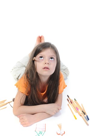 Little beautiful girl draws pencil lying on the floor. Isolated on white backgroundの写真素材