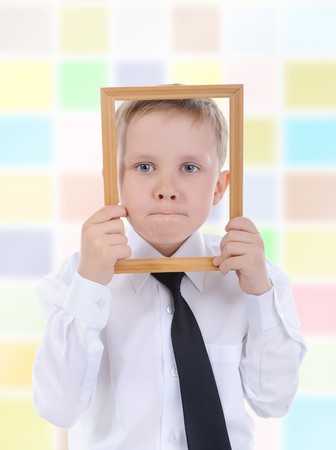 little boy with a wooden frame in his hands.の写真素材