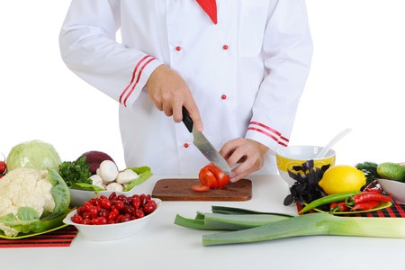 Chef in uniform cuts the vegetables. Isolated on white backgroundの写真素材