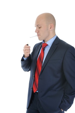 Businessman in suit lights a cigarette. Isolated on white backgroundの写真素材