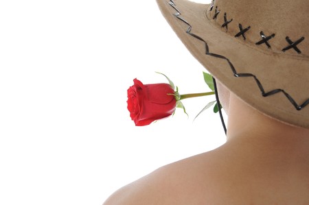 man in a hat holding a red rose in her teeth. Isolated on white backgroundの写真素材