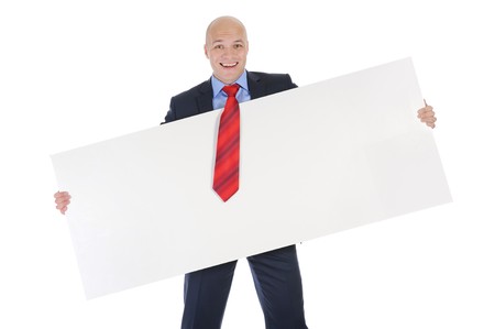 Young smiling businessman in black suit holding large blank. Isolated on white backgroundの写真素材