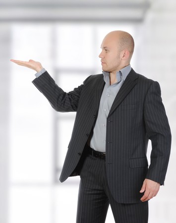 Businessman in a suit holds her hand, palm up. の写真素材
