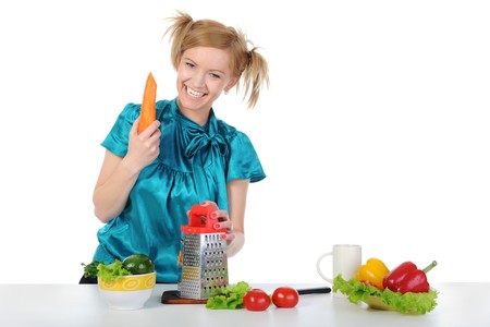 young girl in the kitchen rubbing carrots. Isolated on white backgroundの写真素材