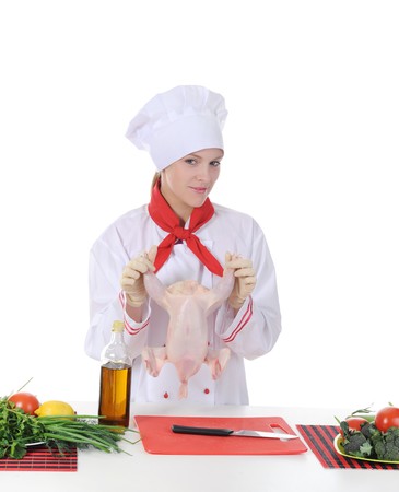 Handsome young chef in uniform prepares chicken. Isolated on white backgroundの写真素材