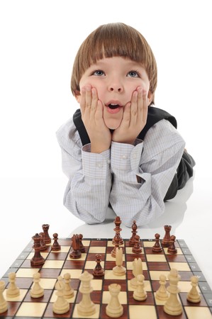 schoolboy playing chess. Isolated on white backgroundの写真素材