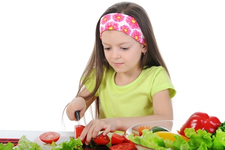 little girl cut fresh tomatoes. Isolated on white backgroundの写真素材