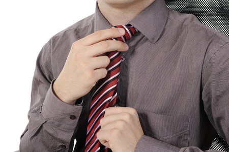 picture of a businessman adjusting his tie. Isolated on white background