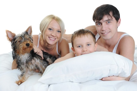 Happy family lying in bed in the morning. Isolated on white backgroundの写真素材