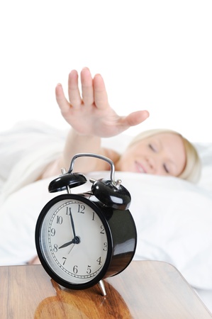 Sleepy woman turns off the alarmの写真素材