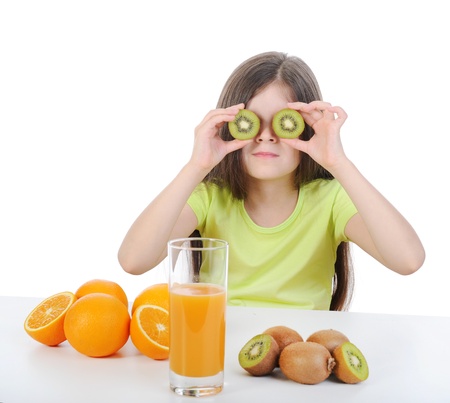Girl with a kiwi at the table.の写真素材