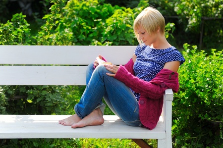 woman reading book in parkの写真素材