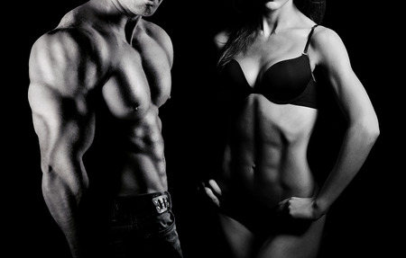 Bodybuilding. Strong man and a woman posing on a black backgroundの写真素材