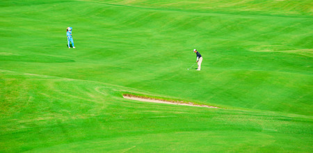 Golf club. Man playing golf Green golf field and ball in grassの写真素材