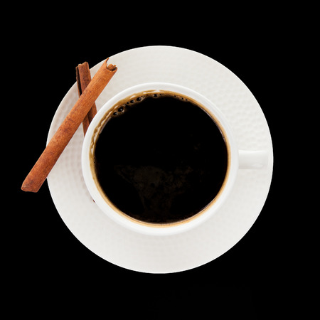 coffee with cinnamon stick isolated on black backgroundの写真素材
