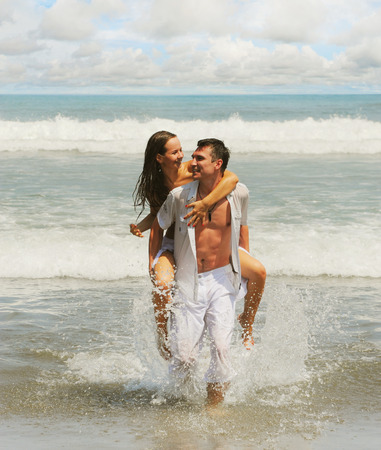 Young beautiful couple in love on a sunny beachの写真素材