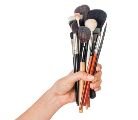 Professional make-up brush cosmetic in female hand beautician isolated on white backgroundの写真素材