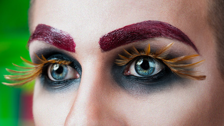 Close-up portrait of the handsome young man fashion model with make-up and big eyelashesの写真素材