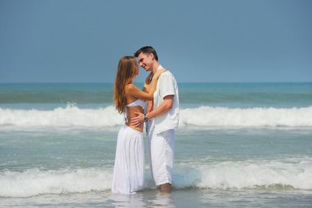 Young beautiful couple in love on a sunny beachの写真素材