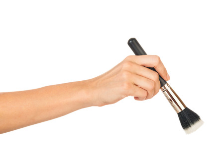 Professional make-up brush cosmetic in female hand beautician isolated on white backgroundの写真素材