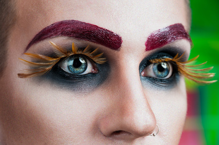 Close-up portrait of the handsome young man fashion model with make-up and big eyelashesの写真素材