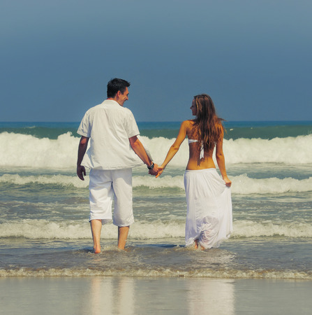 Young beautiful couple in love on a sunny beachの写真素材