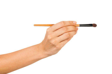 Professional make-up brush cosmetic in female hand beautician isolated on white backgroundの写真素材