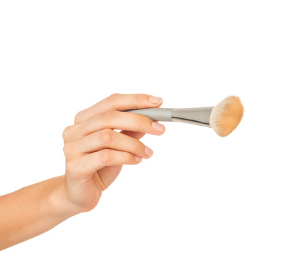 Professional make-up brush cosmetic in female hand beautician isolated on white backgroundの写真素材