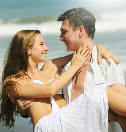 Young beautiful couple in love on a sunny beachの写真素材