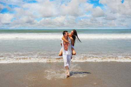 Young beautiful couple in love on a sunny beachの写真素材